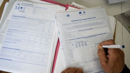 Une personne remplit une déclaration d'impôts sur le revenu, le 21 mars 2022 à Hyères (Var). (MAGALI COHEN / HANS LUCAS / AFP)