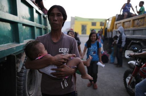 Un père et son fils s'apprêtent à évacuer la ville d'Esperanza (sud des Philippines) dans une zone attaquée par des rebelles des Combattants pour la liberté du Bangsamoro islamique (Biff), le 1er janvier 2016. (AFP  - JEOFFREY MAITEM / NURPHOTO)