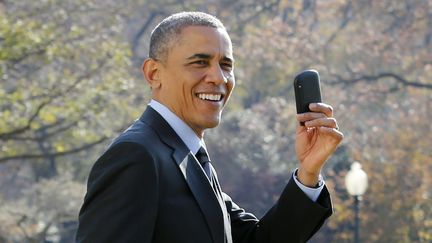 Le pr&eacute;sident am&eacute;ricain Barack Obama montre son t&eacute;l&eacute;phone portable sur la pelouse de la Maison Blanche, &agrave; Washington D.C. (Etats-Unis), le 21 novembre 2014.&nbsp; (YURI GRIPAS / AFP)