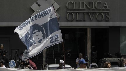 Plusieurs supporters argentins se sont rassemblés devant l'hôpital privé dans lequel s'est fait opéré Diego Maradona début novembre. (EMILIANO LASALVIA / AFP)