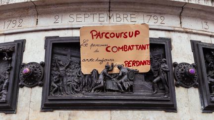 Une pancarte contre la réforme Parcoursup accrochée à la base de la statue de la place de la République, à Paris, le 7 décembre 2018. (MATHIEU MENARD / HANS LUCAS / AFP)