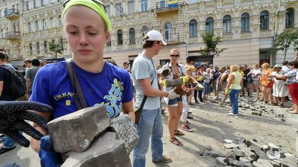 Des habitants de Kiev tentent de d&eacute;barrasser la place Ma&iuml;dan de ses derniers activites, samedi 9 ao&ucirc;t 2014. (SERGEI SUPINSKY / AFP)