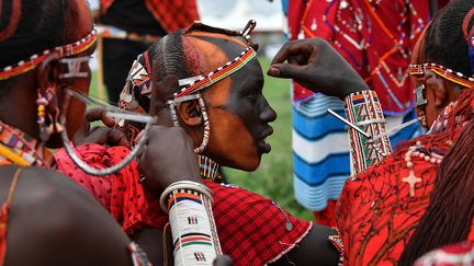 Les festivités se déroulent dans le village de Kimana, près de la frontière tanzanienne, à proximité du parc national d'Amboseli. Avant le début des épreuves, les participants se peignent le visage avec de l'ocre rouge. (TONY KARUMBA / AFP)