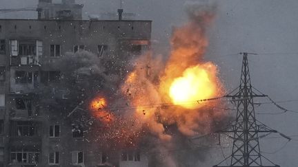 Un immeuble explose après le tir d'un char de l'armée russe à Marioupol, en Ukraine, vendredi 11 mars 2022.&nbsp; (EVGENIY MALOLETKA / AP)