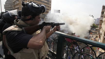 Un policier tire une bombe lacrymog&egrave;ne en direction de partisans des Fr&egrave;res musulmans, le 14 ao&ucirc;t 2013, au Caire (Egypte). (MOHAMED ABD EL GHANY / REUTERS)