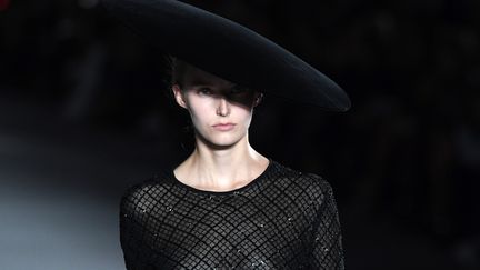 La femme Saint Laurent imaginée par le directeur artistique Anthony Vaccarello est toujours très en jambes, avec des shorts en cuir et des bottes à plumes. Des hommes, en pantalons étroits et blousons précieux, ont aussi foulé le podium.
 (ALAIN JOCARD / AFP)