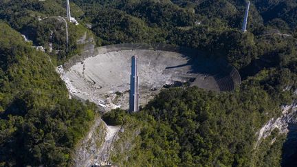 Cette vue aérienne montre les dégâts à l'observatoire d'Arecibo après la rupture d'un des principaux câbles retenant le télescope, à Porto Rico, le 1er décembre 2020. (RICARDO ARDUENGO / AFP)