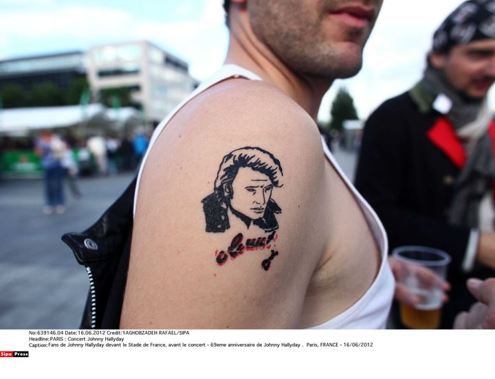 Johnny colle à la peau de&nbsp;certains fans, comme pour cet&nbsp;homme qui se rend à un concert de son idole au stade de France, le 16 juin 2012. (YAGHOBZADEH RAFAEL/SIPA)