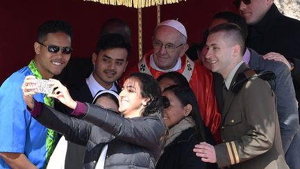 Le pape François prend la pose pour un selfie avec des jeunes fidèles, dimanche 25 mars 2018 sur la place Saint-Pierre au Vatican. (TIZIANA FABI / AFP)