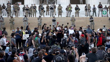 Des membres de la Garde nationale américaine, face à des manifestants, sur les marches du mémorial de Lincoln, à Washington DC (Etats-Unis), le 2 juin 2020. (WIN MCNAMEE / GETTY IMAGES NORTH AMERICA / AFP)