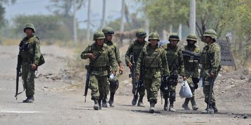 Des soldats mexicains à l'entrée de Tepalcatepec, ville de l'Etat du Michoacán, le 22 mai 2013. Ils recherchent des membres des cartels de la drogue dans cette zone appelée «Tierra Caliente» (terres chaudes).  (AFP PHOTO / ALFREDO ESTRELLA)