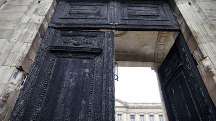 La porte de la mairie de Bordeaux incendiée en marge d'une manifestion contre la réforme des retraites le 23 mars 2023. (ROMAIN PERROCHEAU / AFP)