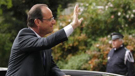 Le nouveau pr&eacute;sident de la R&eacute;publique, Fran&ccedil;ois Hollande, salue la foule de sa voiture en quittant le palais de l'Elys&eacute;e. (STEPHANE MAHE / REUTERS)