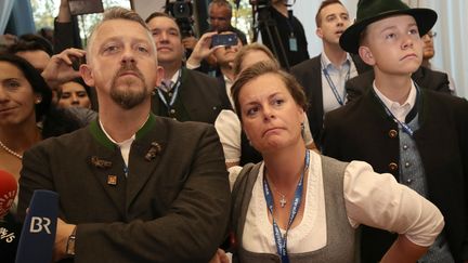 Des soutiens du CSU, le parti allié conservateur d'Angela Merkel, regardent les résultats des élections en Bavière, le 14 octobre 2018. (MICHAEL KAPPELER / DPA / AFP)