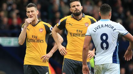 Laurent Koscielny et Olivier Giroud, lors de la défaite d'Arsenal face à WBA (1-3). (LINDSEY PARNABY / AFP)