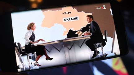 Le président de la République Emmanuel Macron face à la journaliste Carole Roux, sur France 2 le 12 octobre 2022 (MOURAD ALLILI / MAXPPP)