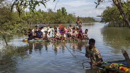 Des Rohingyas arrivent au Bangladesh&nbsp;en traversant la rivière Naf sur un radeau de fortune, le 11 novembre 2017. (ARNAUD FINISTRE / HANS LUCAS / AFP)