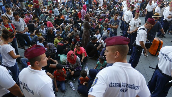 Des officiers de police devant l'entr&eacute;e de la gare de Budapest (Hongrie), face &agrave; des migrants expuls&eacute;s sur le parvis, le 1er septembre 2015. (LASZLO BALOGH / REUTERS)