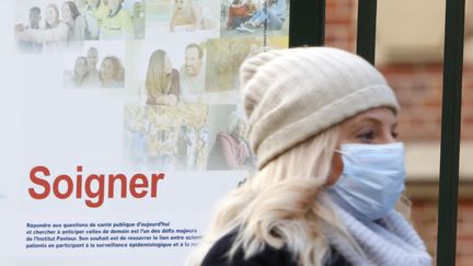 Une femme portant un masque devant l'institut Pasteur à Paris, le 12 mars 2020. (MEHDI TAAMALLAH / NURPHOTO)