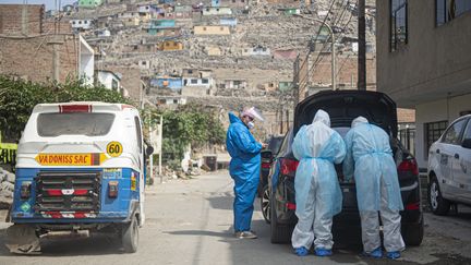 Des médecins rendent visite, le 11 juin 2020, à un malade du Covid-19 dans une banlieue de Lima, au Pérou, désormais un des 10 pays&nbsp;au monde comptant le plus de cas confirmés du virus. (ERNESTO BENAVIDES / AFP)