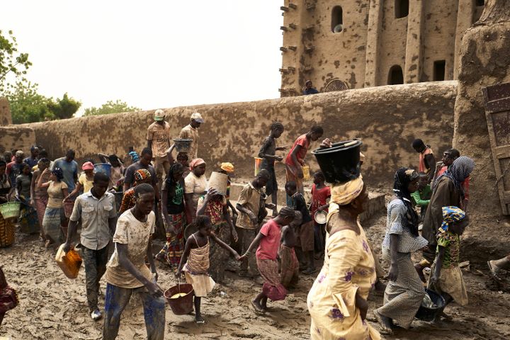 Plusieurs milliers d'habitants de la ville historique de Djenné, au centre du Mali, ont pris part le 28 avril 2019 à la cérémonie de crépissage annuel de la Grande mosquée. (MICHELE CATTANI / AFP)