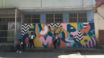 Des fresques ont été peintes au Venezuela par l'artiste franco-britannique Seb Toussaint. Sur cette façade d'école primaire, le mot "compromiso" (engagement) symbolise celui de la directrice à offrir une éducation de qualité à ses élèves.&nbsp; (BENJAMIN DELILLE/ RADIO FRANCE)