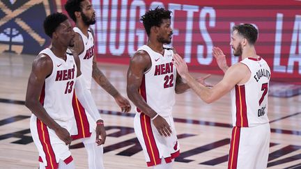 Bam Adebayo, Derrick Jones Jr, Jimmy Butler, et Goran Dragic des Heat de Miami célèbrent leur victoire contre les Celtics de Boston, le jeudi 17 septembre, à Lake Buena Vista, en Floride. (MARK J. TERRILL/AP/SIPA / SIPA)