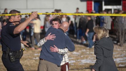 Un p&egrave;re prend son fils dans ses bras, apr&egrave;s une fusillade dans le lyc&eacute;e Arapahoe High School de Centennial&nbsp;(Etats-Unis), le 13 d&eacute;cembre 2013. (EVAN SEMON / REUTERS)