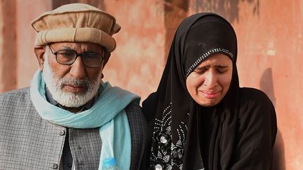 Une femme et un homme arrivent &agrave; proximit&eacute; de l'&eacute;cole de Peshawar (Pakistan) o&ugrave; a eu lieu une attaque terroriste faisant 141 morts dont 132 enfants, le 16 d&eacute;cembre 2014. (A MAJEED / AFP)