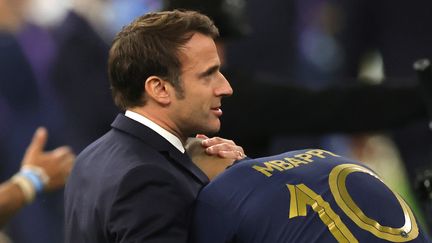 Le président français, Emmanuel Macron, avec Kylian Mbappé, après la défaite de la France contre l'Argentine, en finale de la Coupe du monde, le 18 décembre 2022. (FRIEDEMANN VOGEL / EPA)