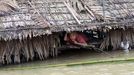 Un jeune gar&ccedil;on est r&eacute;fugi&eacute; dans sa maison immerg&eacute;e par les eaux de la mousson &agrave; Pathein (Birmanie), le 20 ao&ucirc;t 2012. (YE AUNG THU / AFP)