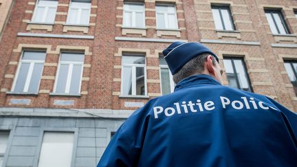 Un agent de police dans une rue de Molenbeek (Belgique), le 19 mars 2016, au lendemain de l'arrestation de Salah Abdeslam. (MAXPPP)