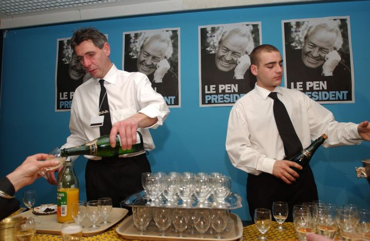 Des serveurs préparent des verres de crémant pour les sympathisants du Front national, le 21 avril 2002, à Saint-Cloud, au quartier général de Jean-Marie Le Pen. (ERIC FEFERBERG / AFP)