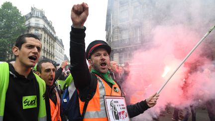 Deux salariés de la SNCF manifestent devant la gare de l'Est, le 14 mai 2018 à Paris. (ERIC FEFERBERG / AFP)