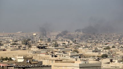 Une photo prise le 6 novembre 2016 montre de la fumée s'élevant d'immeubles, au sud de Mossoul (Irak). (AHMAD AL-RUBAYE / AFP)