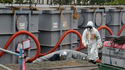 Un employ&eacute; de Tepco (Tokyo Electric Power) travaillant sur les cuves de stockage des eaux contamin&eacute;es, le 12 juin 2013, &agrave; Fukushima (Japon).&nbsp; (NOBORU HASHIMOTO / AFP)