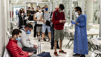 Des passagers soumis à un contrôle de symptômes du Covid-19 à l'aéroport international Lamaca de Chypre, en juin 2020. (IAKOVOS HATZISTAVROU / AFP)