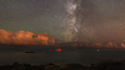 Une &eacute;toile filante dans la Voie lact&eacute;e laisse une trace dans le ciel au-dessus de la mer, dans le&nbsp;Finist&egrave;re, le 23 mars 2013. (LAURENT LAVEDER / BIOSPHOTO / AFP)