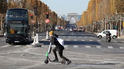 Un homme sur une trottinette traverse les Champs-Elysées, à Paris, le 9 novembre 2018.&nbsp; (CHARLES PLATIAU / REUTERS)