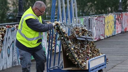 &nbsp; (Un employé municipal s'affaire à enlever les cadenas de l'amour sur le Pont-des-Arts © MaxPPP)