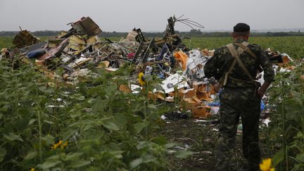 Un s&eacute;paratiste prorusse sur les lieux du crash du vol MH17 de la Malaysia Airlines, vendredi 18 juillet 2014. (MAXIM ZMEYEV / REUTERS)