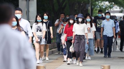 Des passants portent un masque&nbsp;à Pékin, le 8 juin 2020.&nbsp; (KOKI KATAOKA / YOMIURI / AFP)