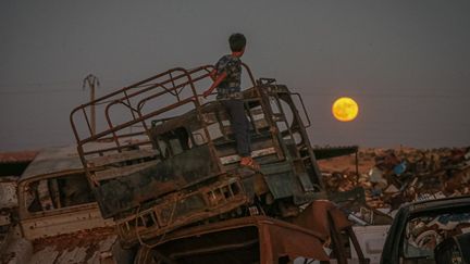 Un enfant observe la "super lune", monté sur un camion, à Idlib (Syrie).&nbsp; (MUHAMMED SAID / ANADOLU AGENCY / AFP)