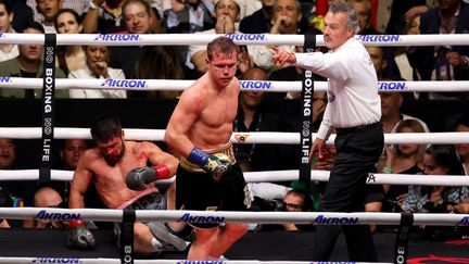 Le boxeur Mexicain Saul "Canelo" Alvarez (debout) lors de son combat face au Britannique John Ryders (au sol), au stade Akron de Guadalajara, au Mexique, le 6 mai 2023. (ULISES RUIZ / AFP)