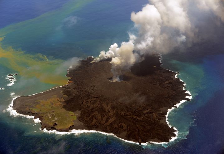 A droite, l'&icirc;lot volcanique apparu en novembre 2013 s'&eacute;tale d&eacute;sormais sur l'&icirc;le Nishinoshima (&agrave; gauche), le 23 juillet 2014, au large du Japon. (JAPAN COAST GUARD / AFP)