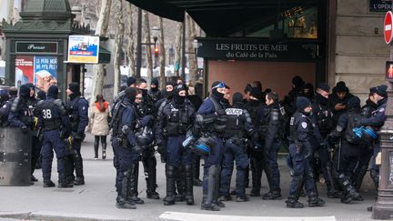 Des policiers devant le Café de la Paix, place de l'Opéra, à Paris, lors d'une journée de mobilisation des "gilets jaunes", le 15&nbsp;décembre 2018.&nbsp; (MICHEL STOUPAK / NURPHOTO / AFP)