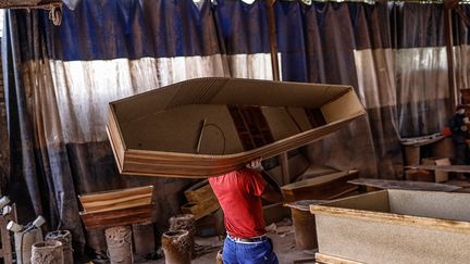 Un cercueil peut être fabriqué en vingt minutes. Mais ce qui manque, ce n'est pas le temps, c'est la matière première car depuis le début de la seconde vague, l'entreprise fait face à une pénurie de bois.&nbsp; &nbsp; (GUILLEM SARTORIO / AFP)