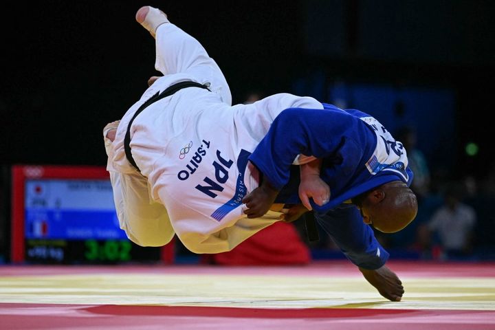 Teddy Riner monte sur le tatami en sachant qu'une victoire est impérative. Face au solide Tatsuru Saito, cinquième en individuel chez les lourds, le champion olympique de la catégorie doit s'y prendre à plusieurs reprises avant de parvenir à ses fins. Au terme de trois minutes de golden score, l'ippon salvateur survient. Les Bleus respirent : ils ne sont plus menés que 2 à 1. (LUIS ROBAYO / AFP)