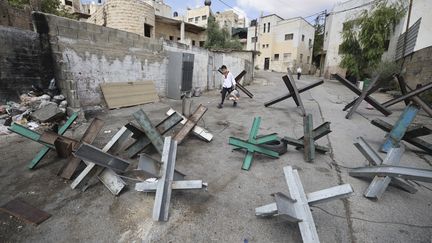 Un garçon marche à travers des barricades érigées par des Palestiniens, à Jénine, en Cisjordanie occupée, le 20 juin 2023. (JAAFAR ASHTIYEH / AFP)