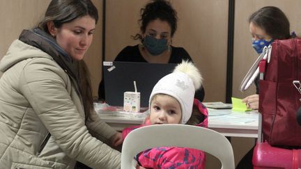 Une famille est en entretien avec des membres de l'ONG France Terre d'asile dans le "hub" du parc des expositions, à Paris,&nbsp;le 18 mars 2022. (ELOISE BARTOLI / FRANCEINFO)